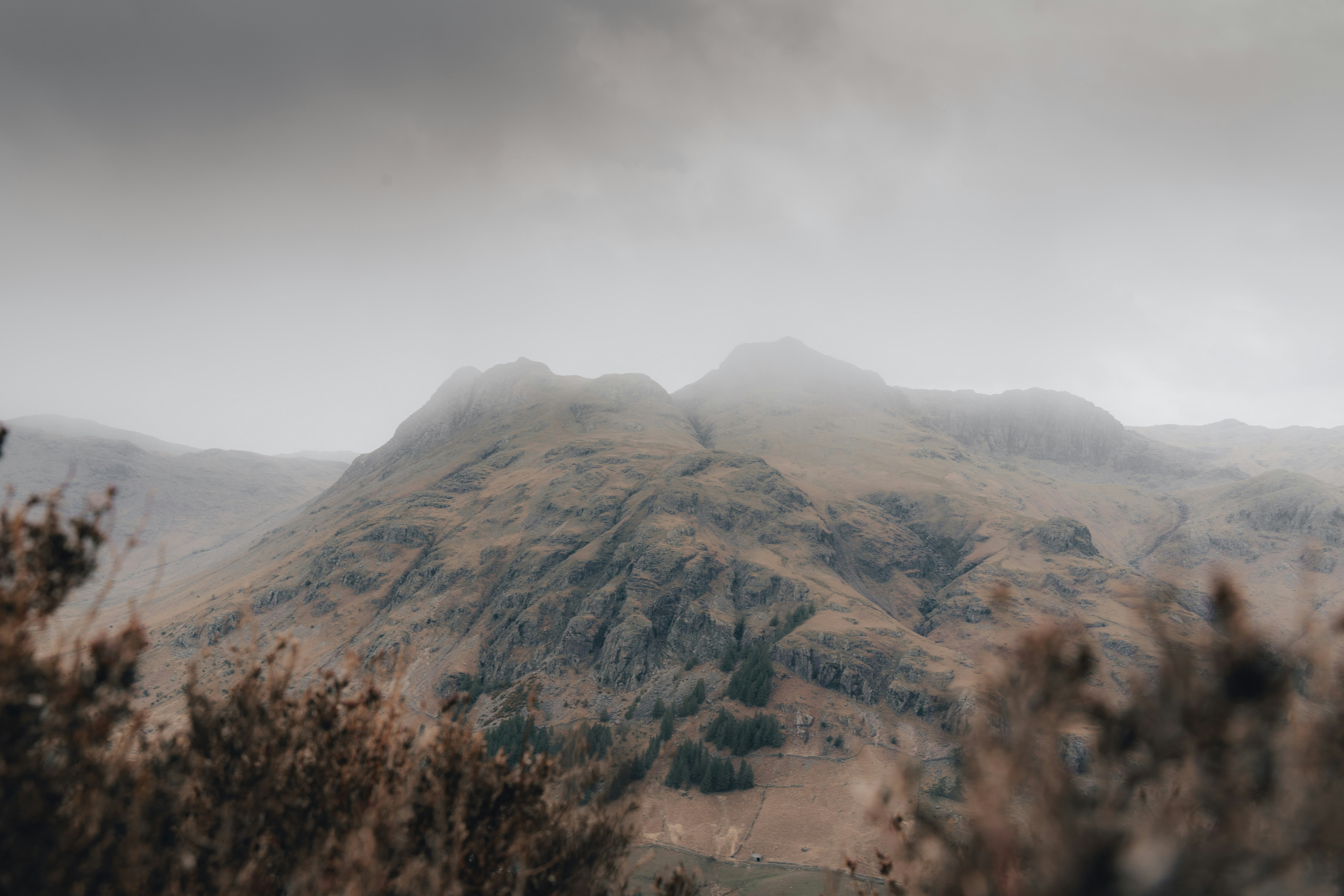 brown and green mountains under white clouds during daytime